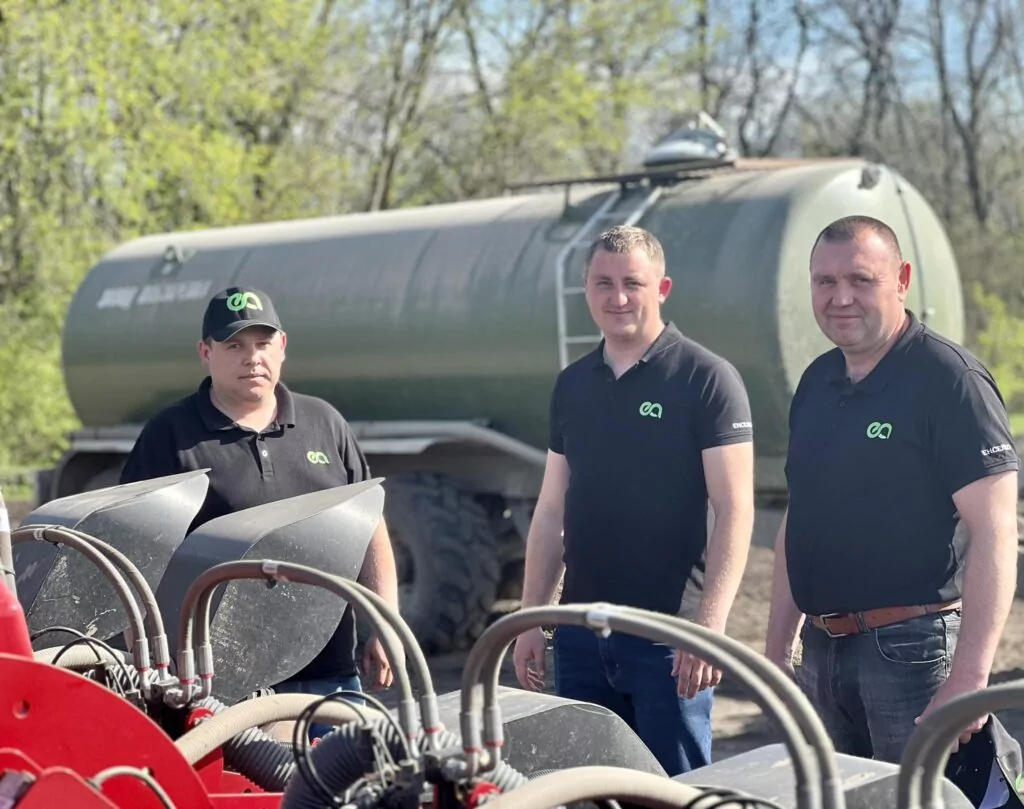 три чоловіки біля сільскогосподарської техніки